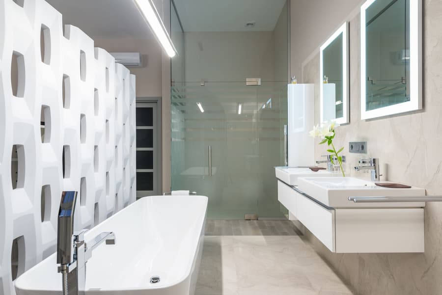 A finished bathroom with a freestanding bath and full-height glass